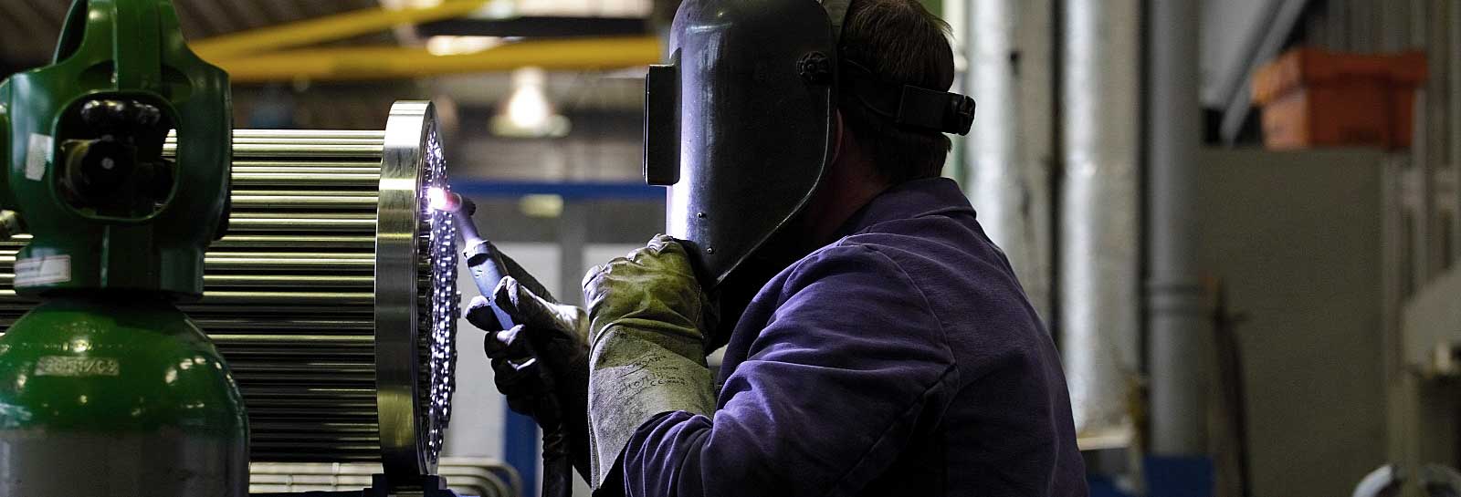 An employee welding a filigree part of a heat exchanger.